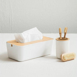 White tissue box with wooden top and holder on a light gray background