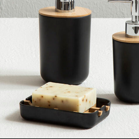 Black soap dispensers with wooden accents on a white surface.