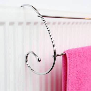 Chrome towel rack with a pink towel on a white radiator