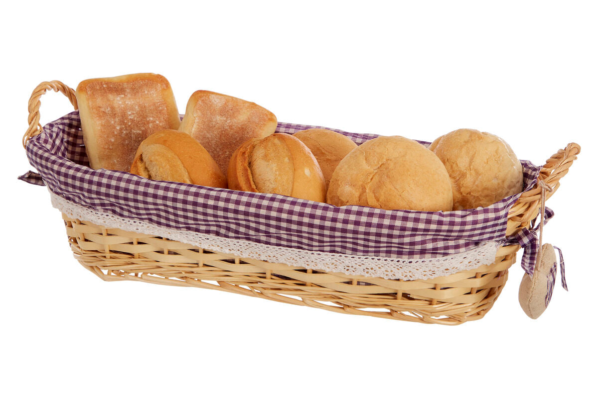 Wicker bread basket with checkered liner containing bread rolls on a white background