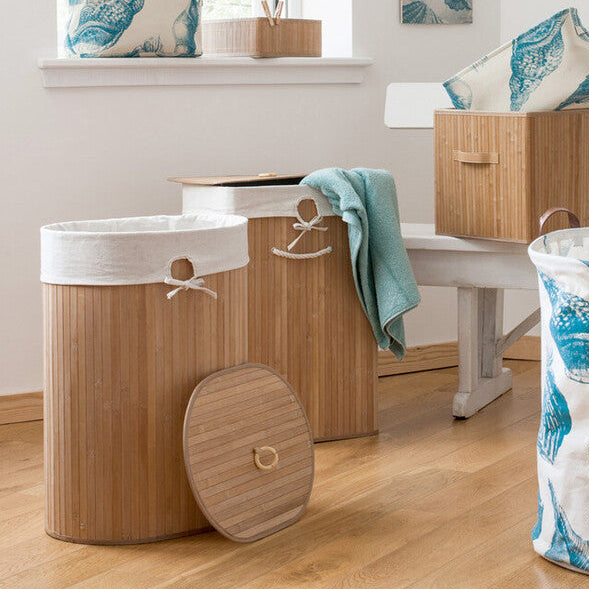 Laundry baskets with leaf pattern on a wooden floor in a room with a mirror and window.