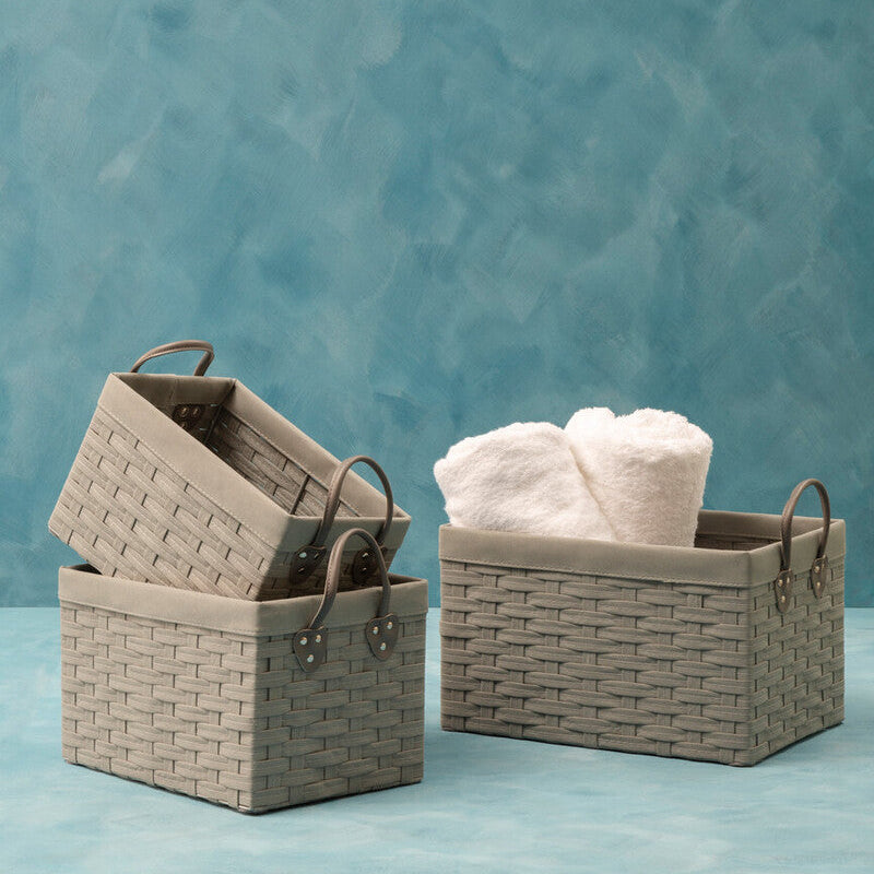 Set of woven baskets with towels against a textured blue background