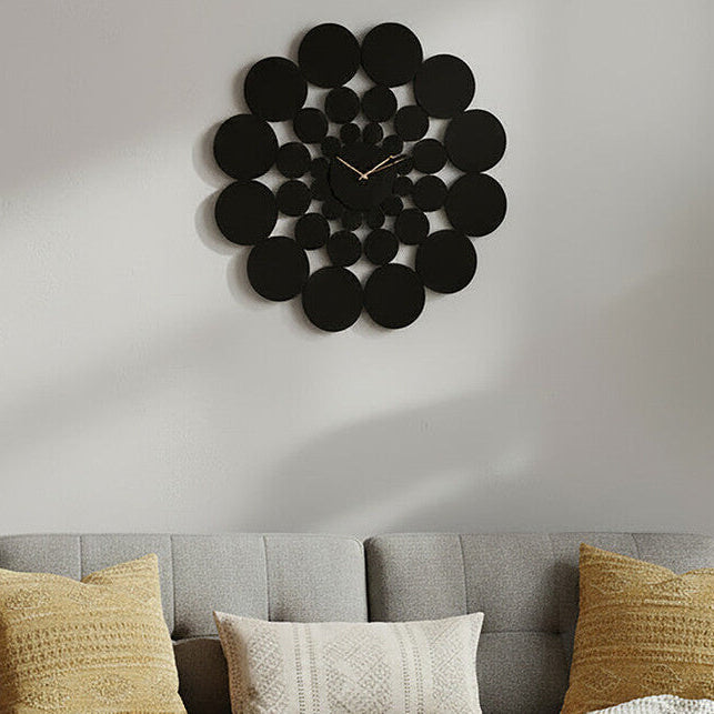 Gray sofa with decorative pillows and a modern wall clock in a living room setting.