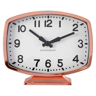 Rose gold clock with white face on a white background
