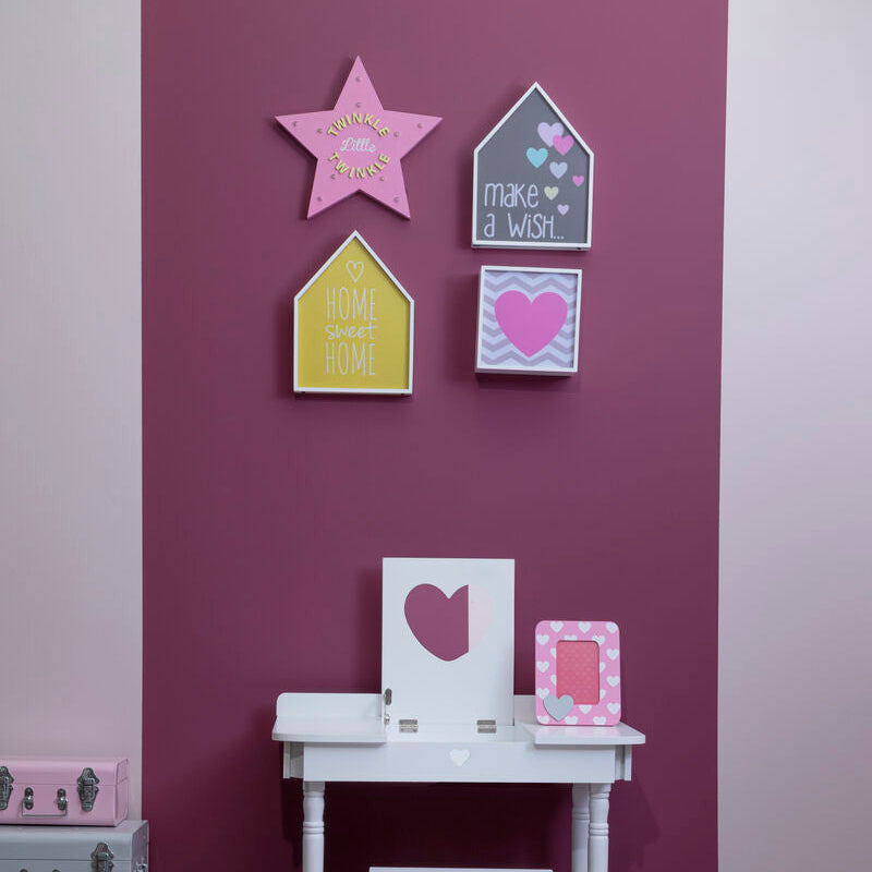 Decorative wall art on a purple wall with a small white table and stools.