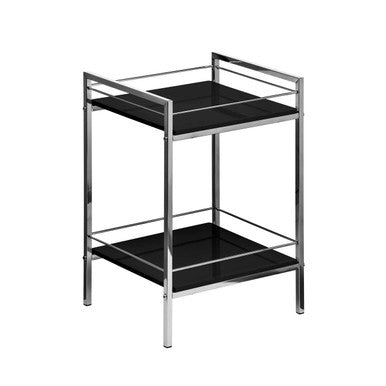 Two-tiered metal and black glass side table on a white background