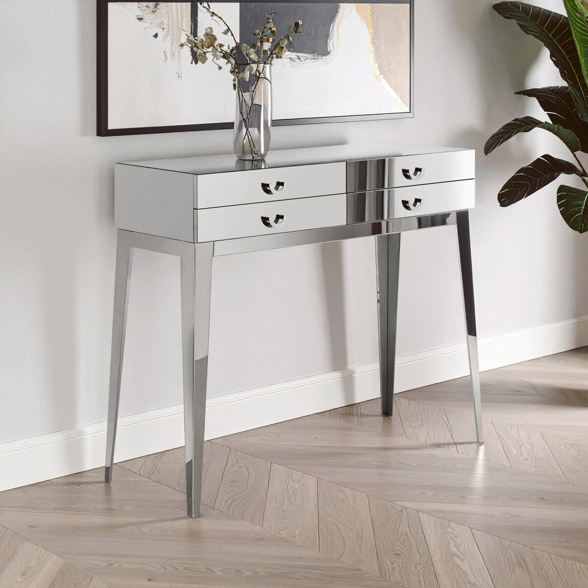 Mirrored console table with three drawers in a room setting.