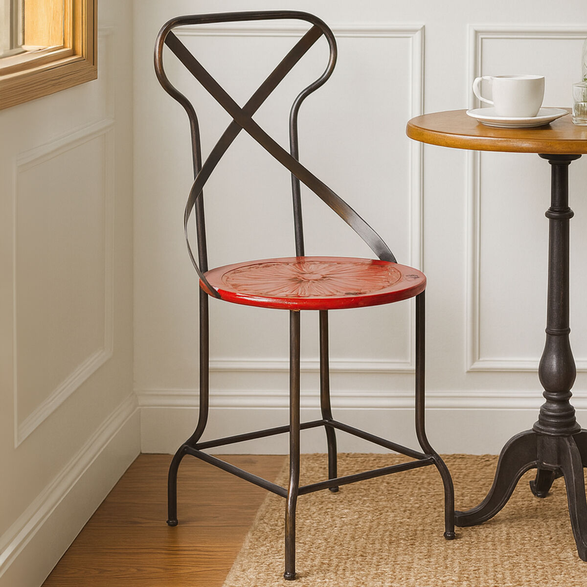 Red bar stool with black metal frame in a room with a wooden floor and white walls.