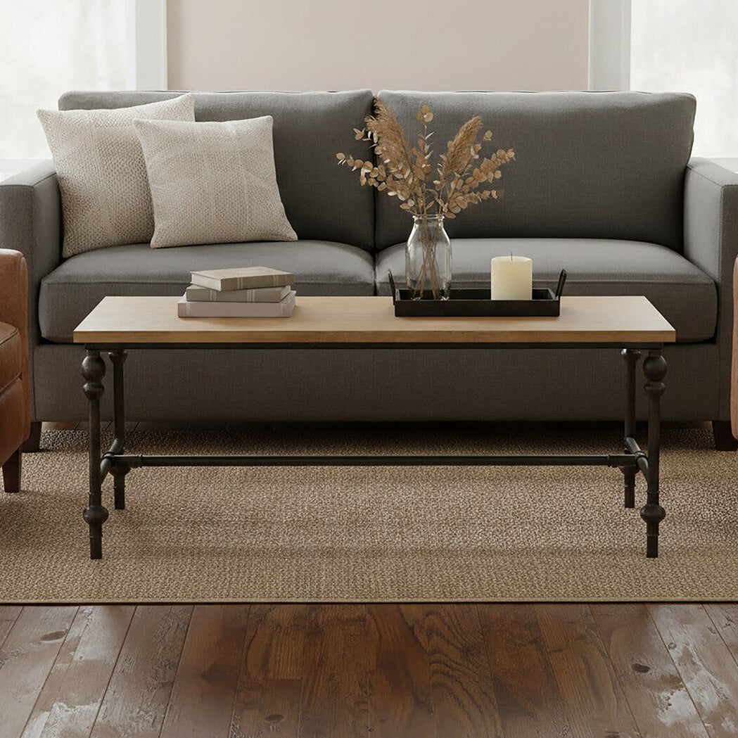 Gray sofa with brown armchairs and a wooden coffee table in a living room setting.