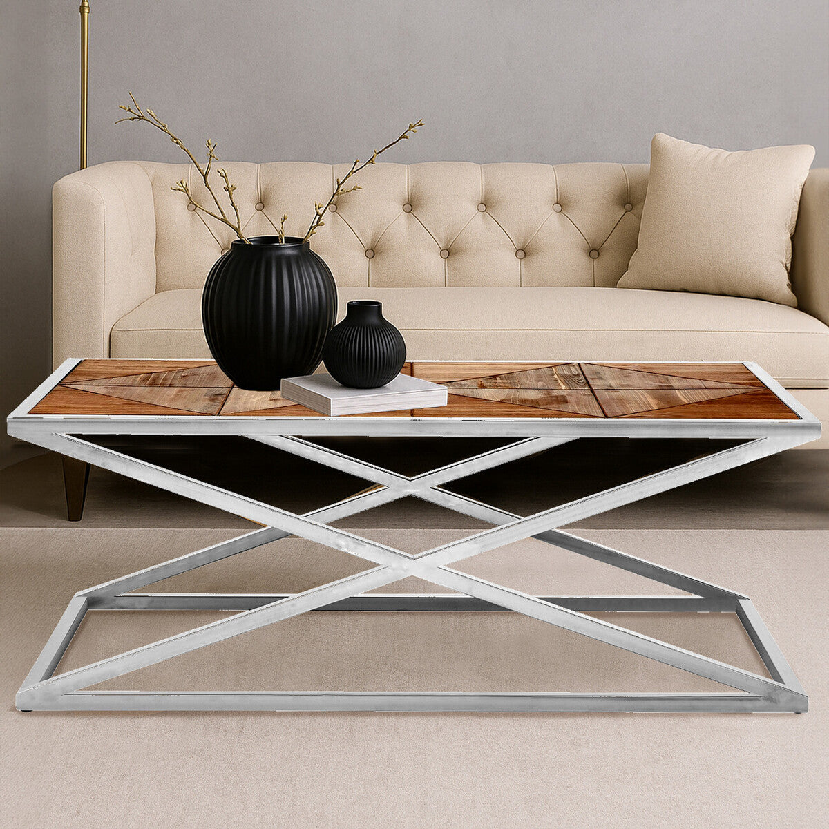 Beige sofa with a wooden coffee table featuring a metal base, black vases, and branches.