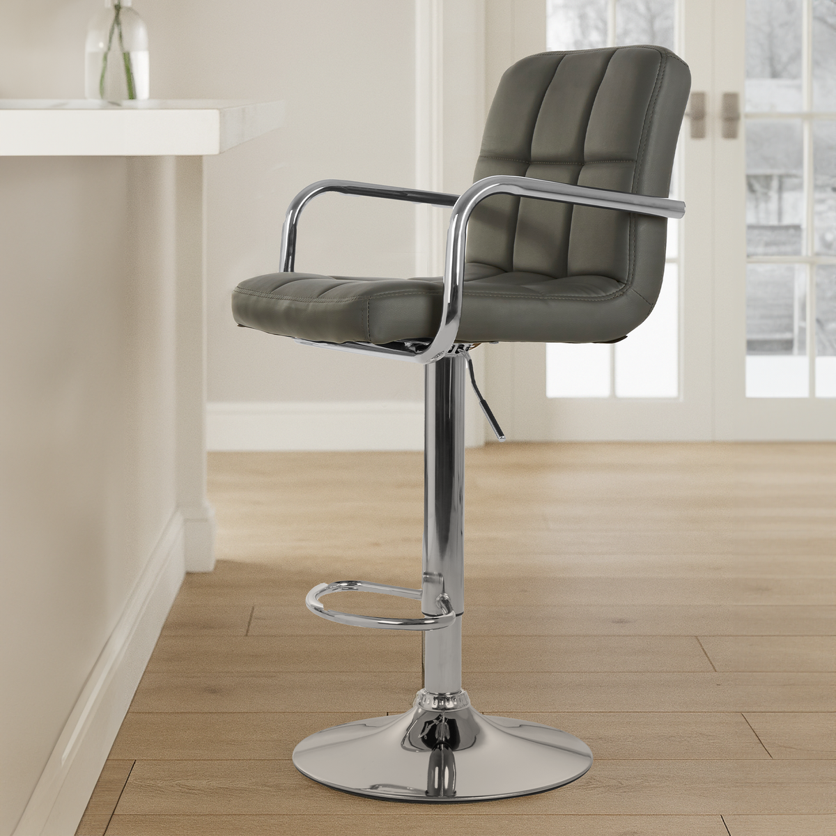 Gray bar stool with chrome base in a room with a table and window.