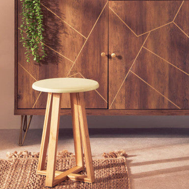 Wooden cabinet with geometric design and a stool in front, on a neutral background