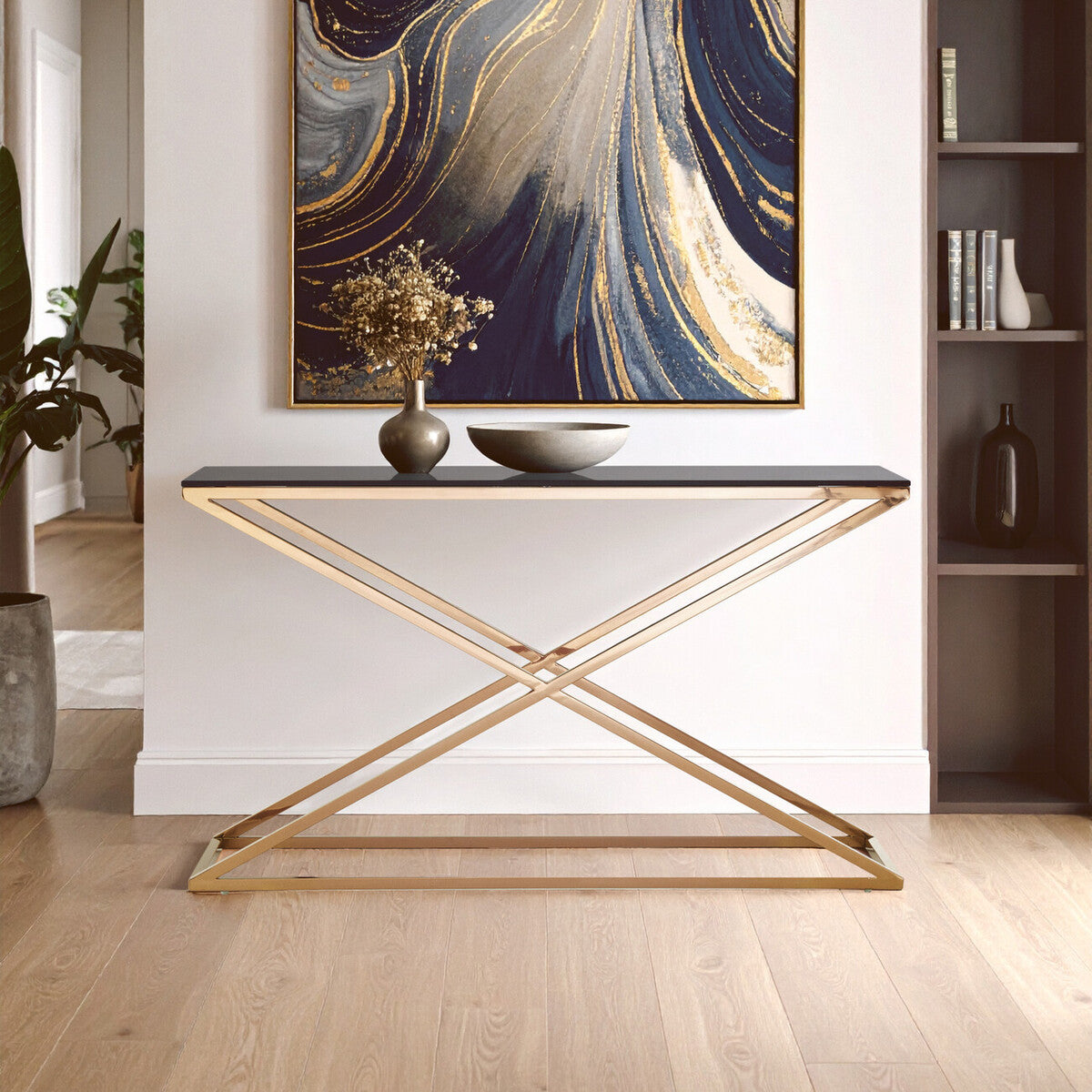 Modern console table with gold legs in a room with abstract art and decor.