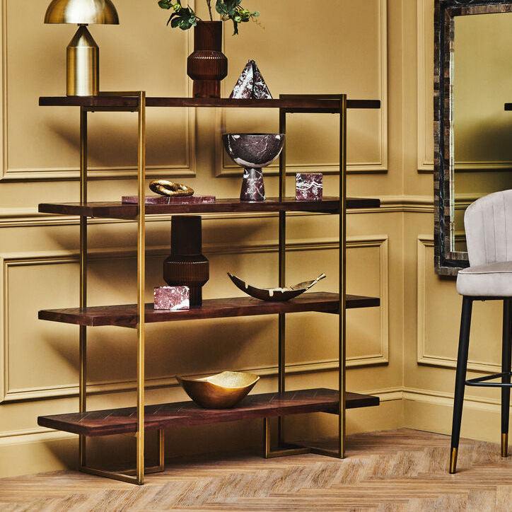 Decorative interior setting with a shelf, mirror, and chair against a beige wall.