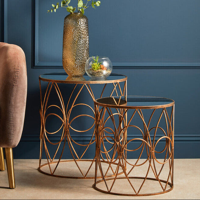 Bronze side table with decorative items against a blue wall