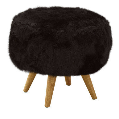 Round black fur stool with wooden legs on a white background