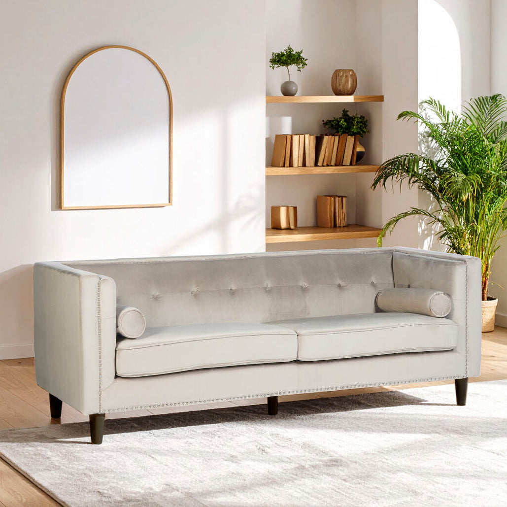 Gray sofa in a modern living room with a mirror, shelves, and plant.