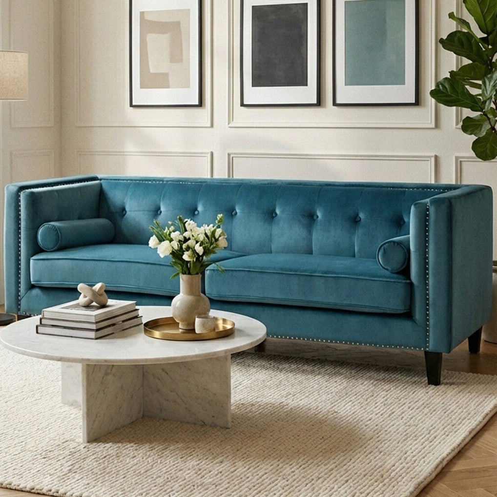Blue sofa in a living room with a marble coffee table and decorative elements.
