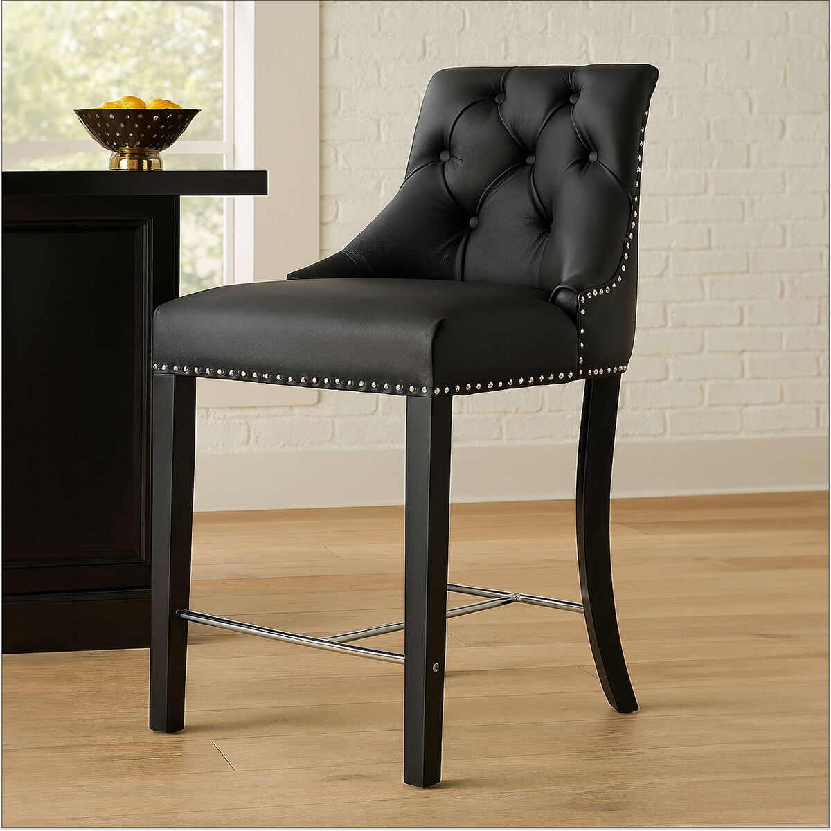 Black bar stool with tufted backrest and nailhead trim in a room setting.