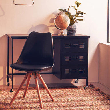 Modern office setup with black chair, black filing cabinet, and decorative items.