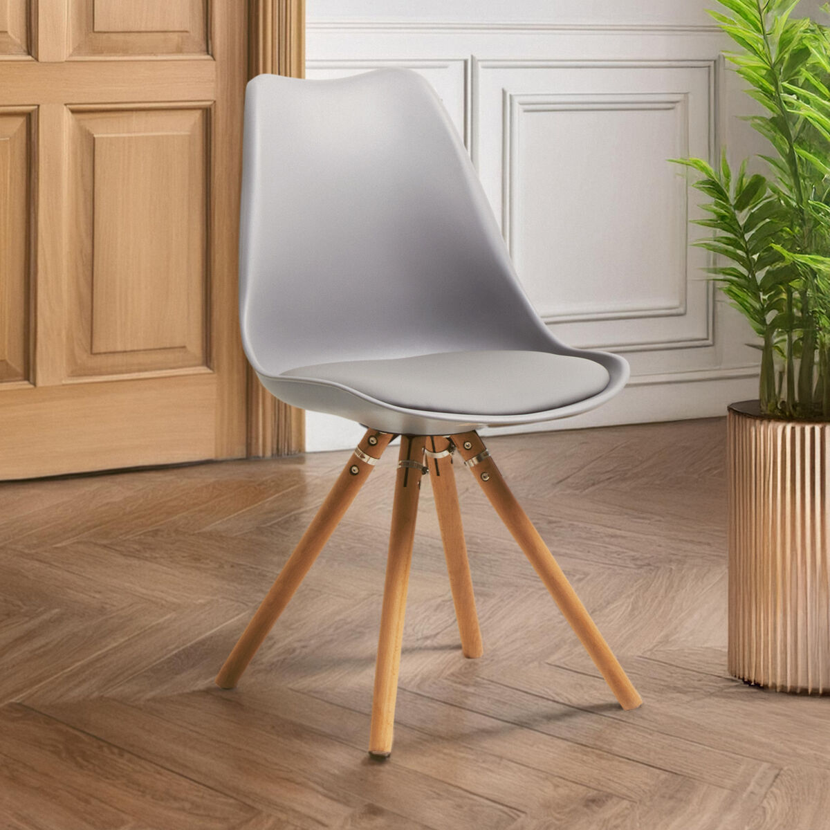 Modern chair with wooden legs on a wooden floor, next to a plant.