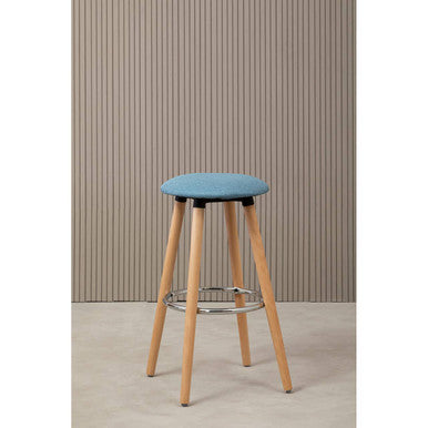 Bar stool with a blue seat and wooden legs against a striped wall.