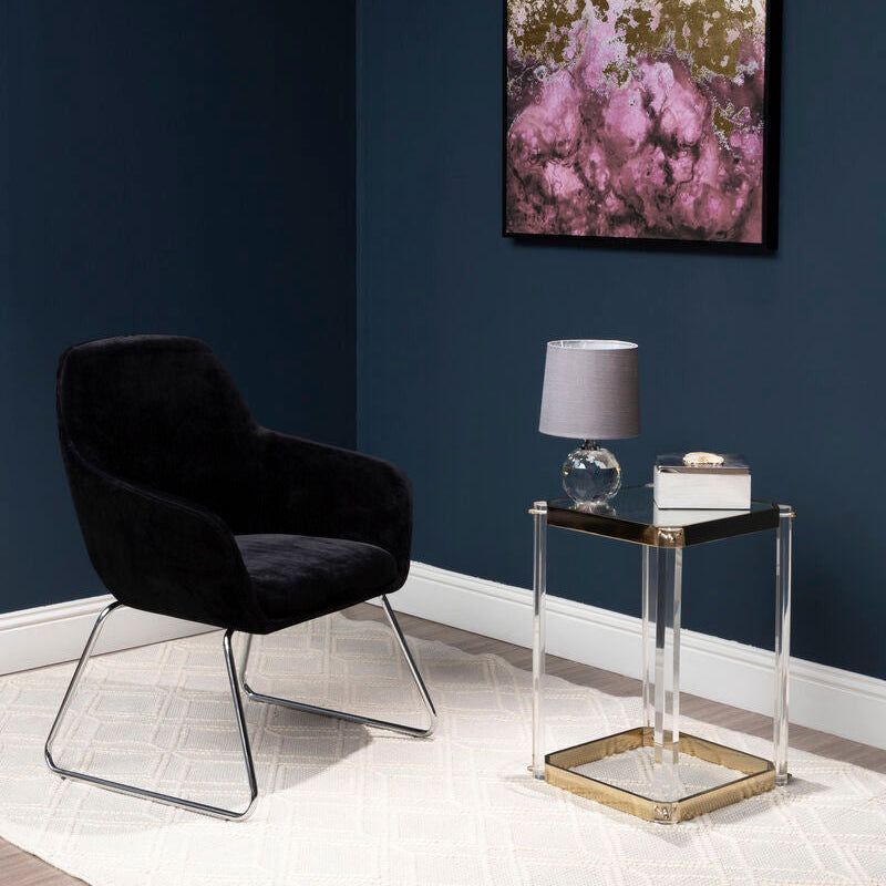 Modern black armchair in a room with a dark blue wall, side table, and abstract art.