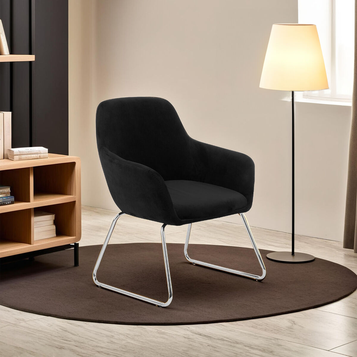Black armchair in a modern living room with a lamp and bookshelf.