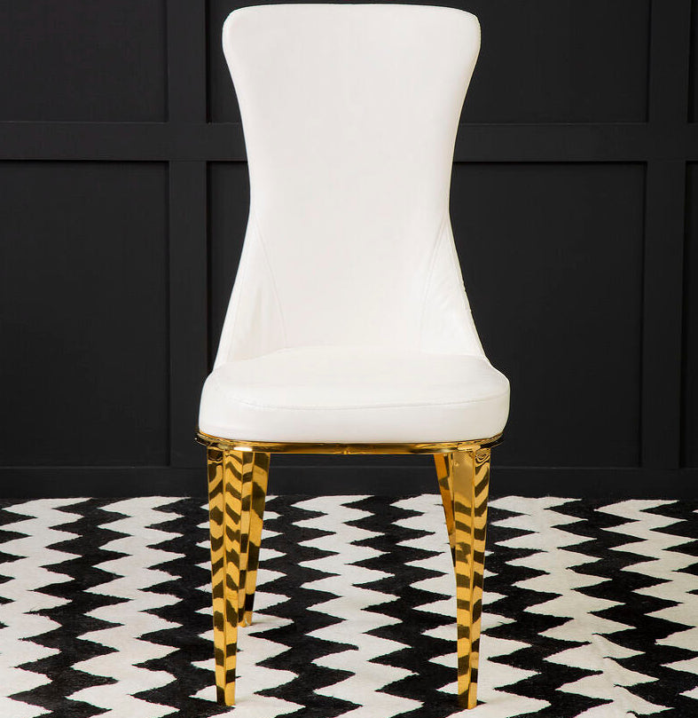 White chair with gold legs on a black and white patterned rug