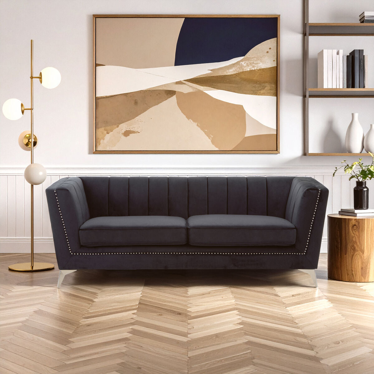 Modern living room with a dark gray sofa, abstract painting, and decorative items.