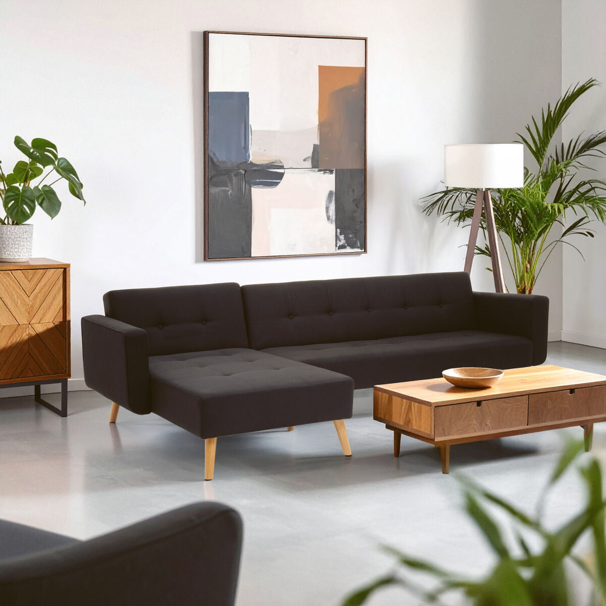 Modern living room with a black sofa, wooden coffee table, and abstract art on the wall.