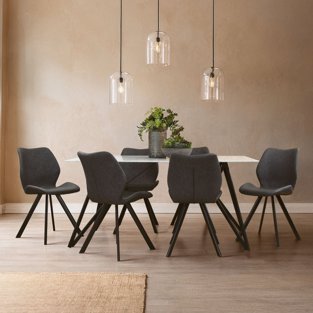 Dining room with a table and chairs under pendant lights.