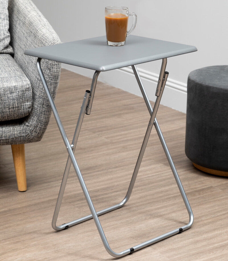Small folding table with a glass of coffee on a wooden floor next to a