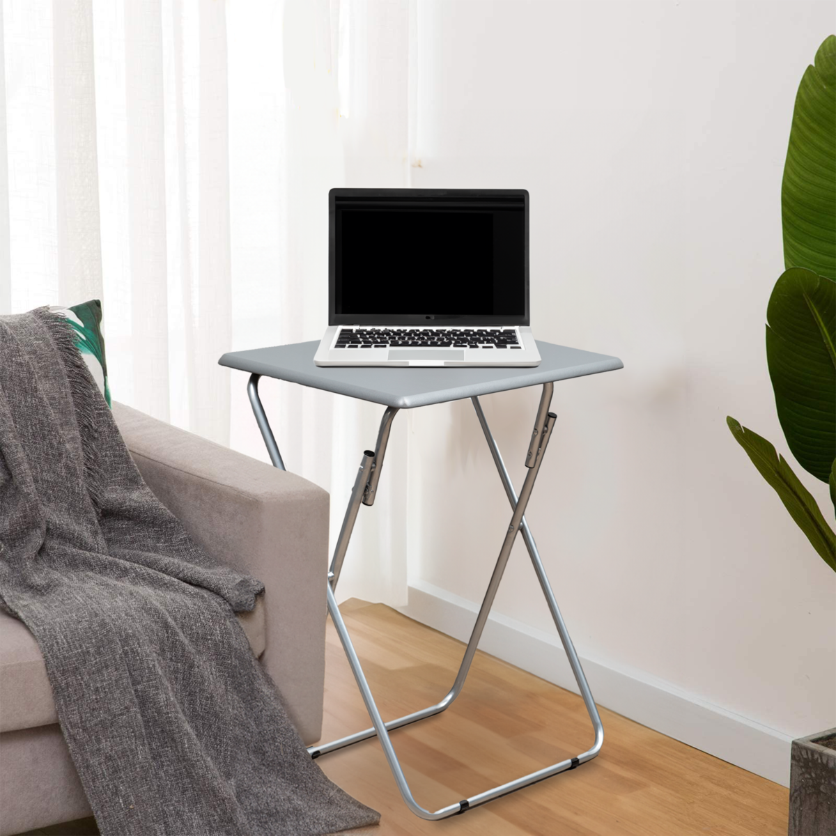 Foldable table with a laptop on it in a home setting