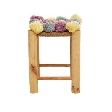 Wooden bar stool with colorful pom-pom cushion on a white background