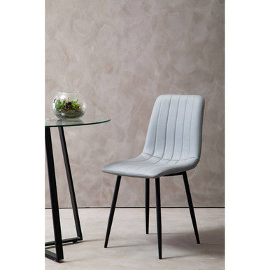 Gray chair with black legs in a minimalistic setting