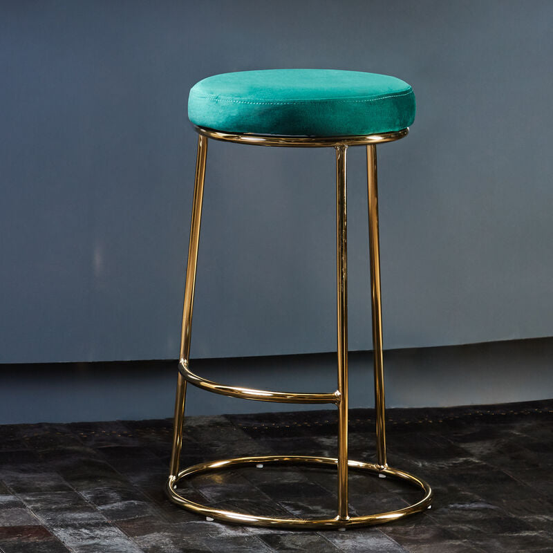 Teal bar stool with gold legs against a blue wall