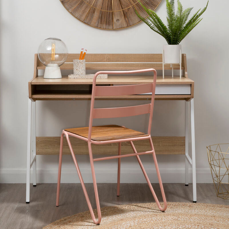 Wooden desk with pink chair, round wooden clock on wall, and plant in room.