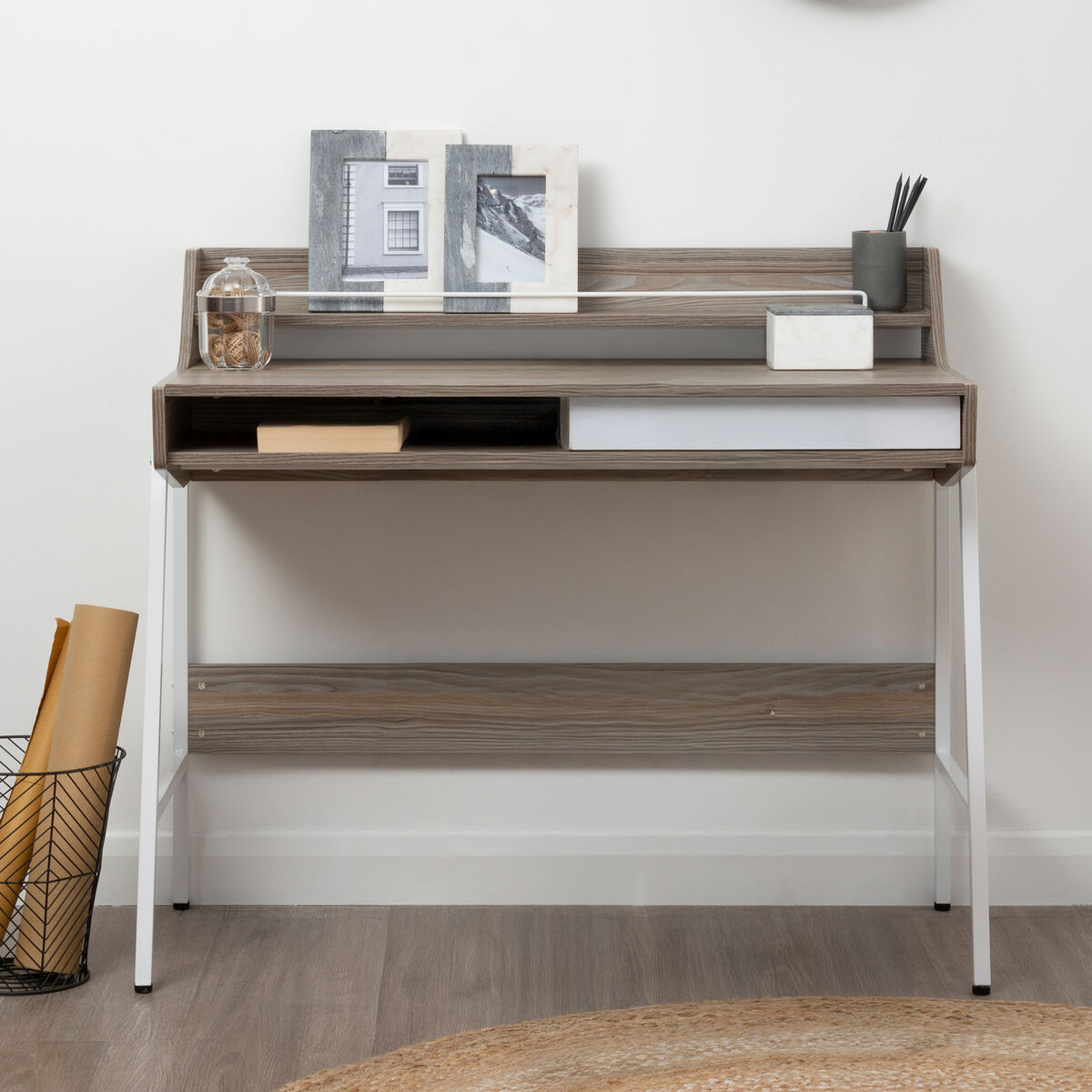 Wooden desk with shelves and decorative items against a white wall.