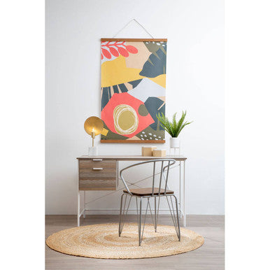 Modern office desk with chair, abstract art, and decor items on a white wall.
