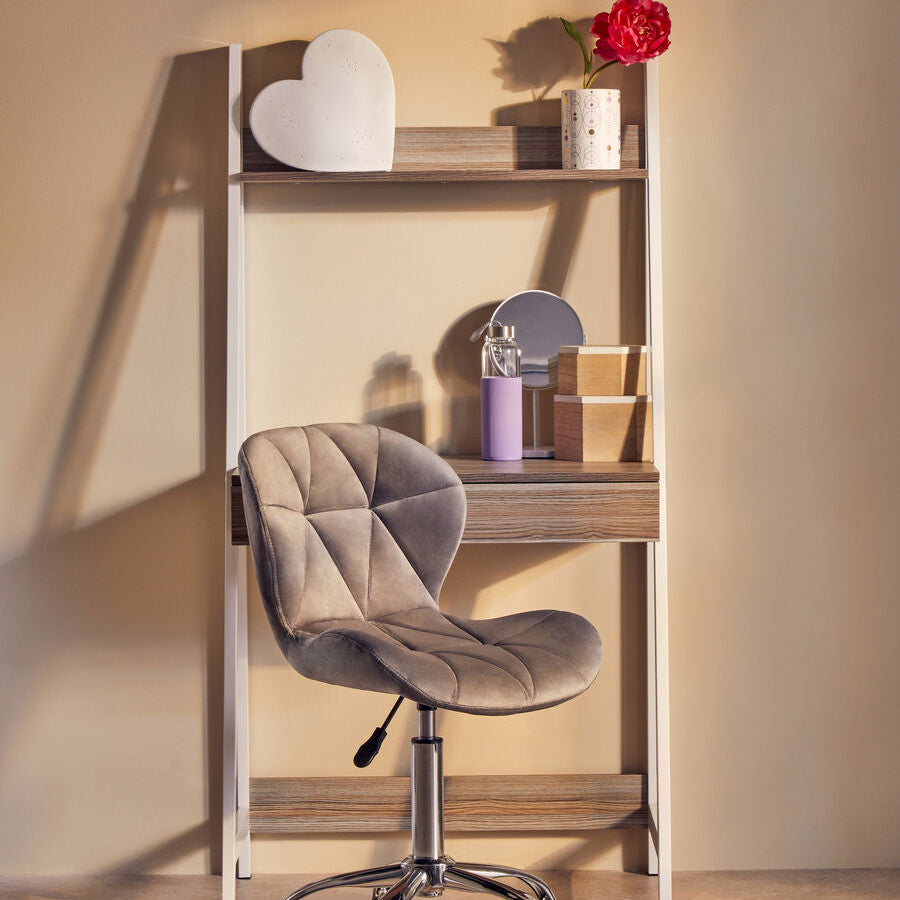Small wooden desk with a gray chair against a beige wall