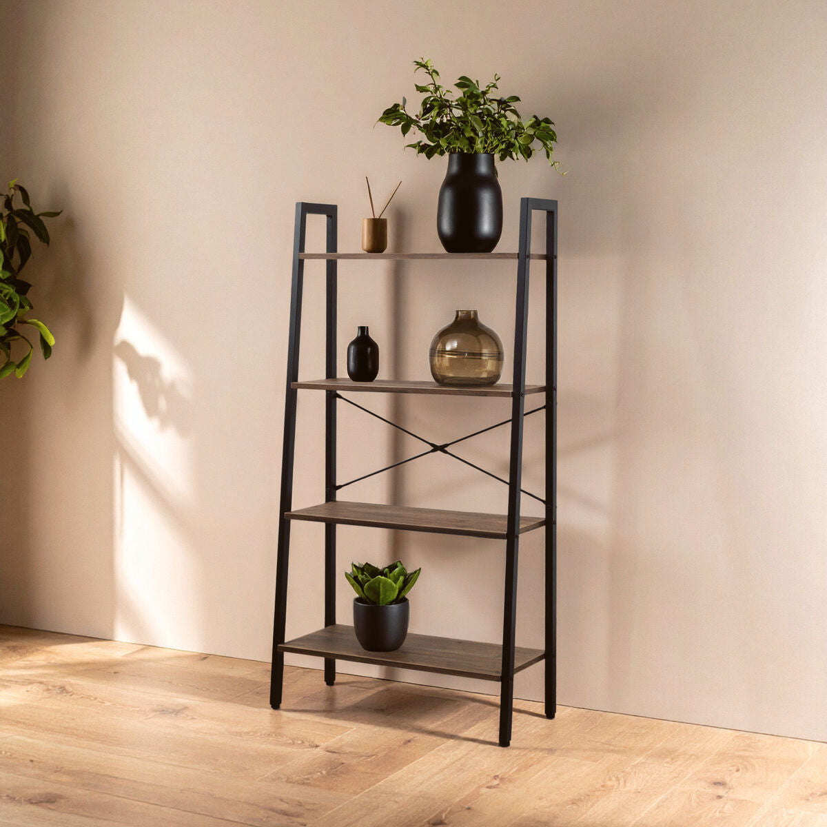 Ladder-style bookshelf with decorative items against a beige wall.
