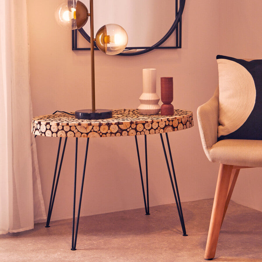 Small round table with decorative items in a room with a mirror and chair.