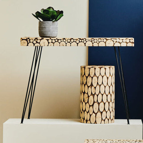 Modern furniture set with tables, stools, and a lamp against a blue wall.