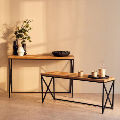 Two wooden tables with metal legs against a beige wall.