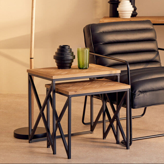 Modern black leather chair with wooden side table and lamp in a room setting.