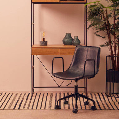 Modern office setup with a wooden desk, chair, and shelves against a beige wall.