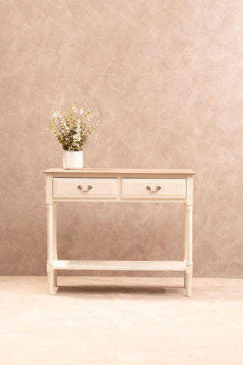 Wooden side table with a vase of flowers against a beige wall.