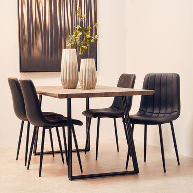 Dining table with four chairs and decorative vases in a modern interior setting.