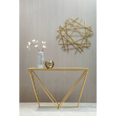 Gold console table with decorative items against a striped wall.